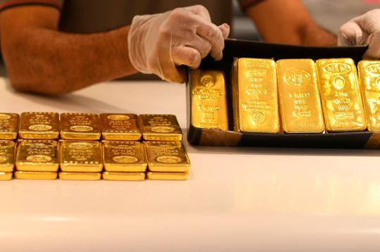 Gold futures settle back above $1,800 as U.S. dollar retreats